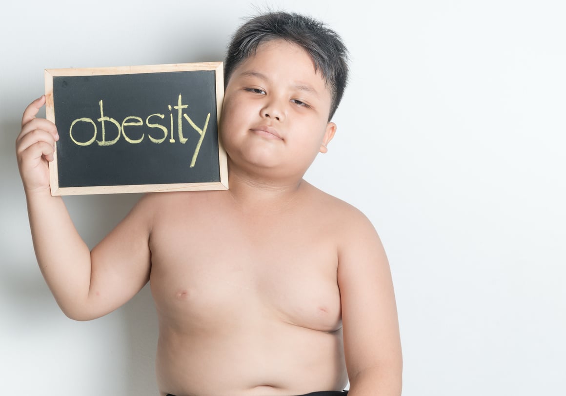 Boy Holding a Chalkboard with Obesity Text