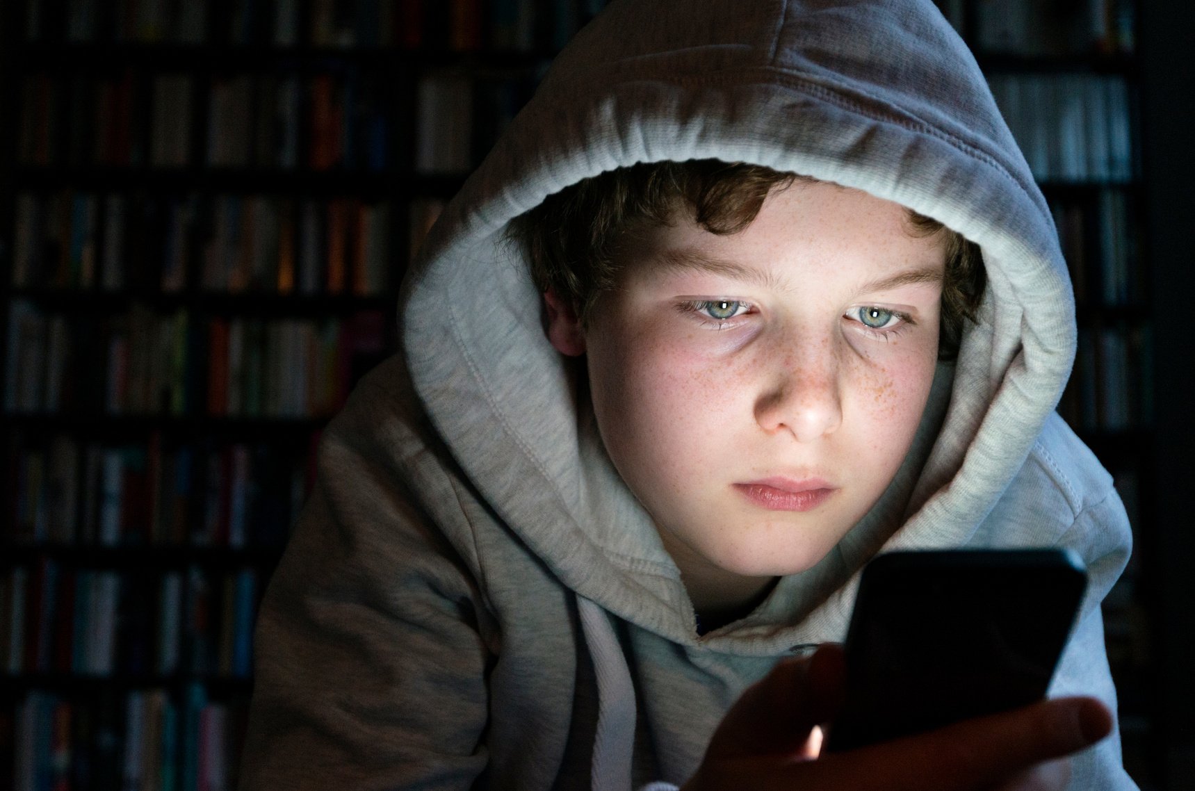 Young Teen Playing on His Mobile Phone.